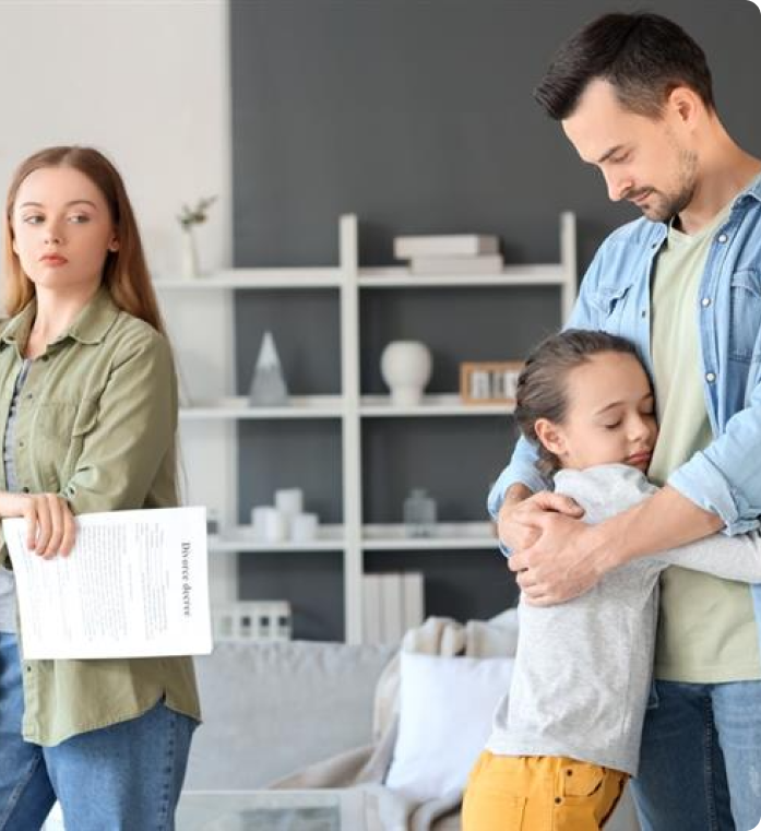 A woman holds a "Divorce decree" while a man comforts a young girl in the background.