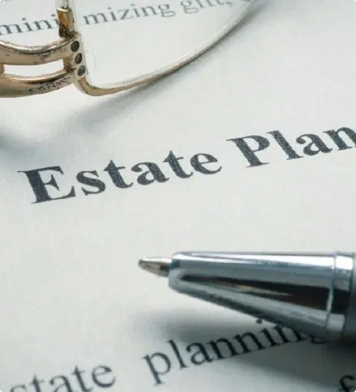 A close-up shot of a document titled "Estate Planning" with a pen and eyeglasses resting on it.